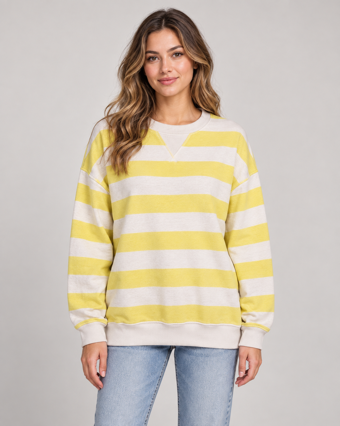 Female model wearing a yellow and white striped crew neck sweatshirt