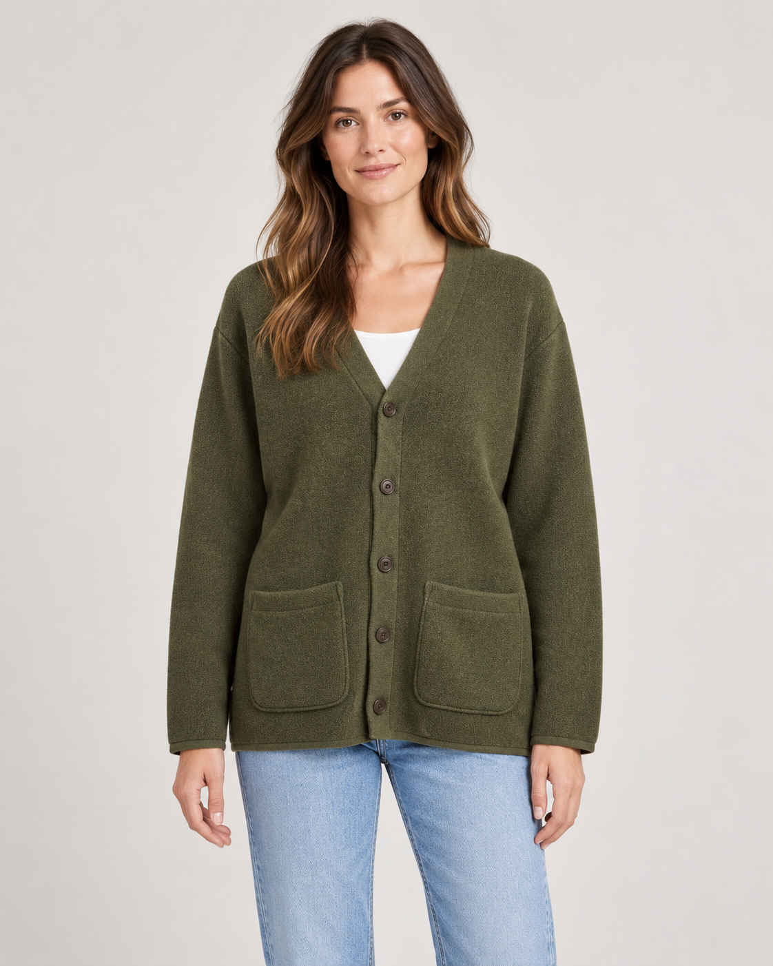 Female model wearing the GR London khaki V-neck cardigan with two front pockets