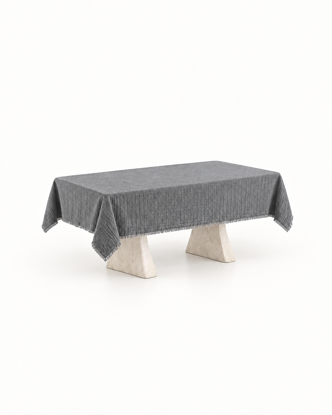 Grey textured cotton six-seater tablecloth on a stone pedestal table with a plain studio background