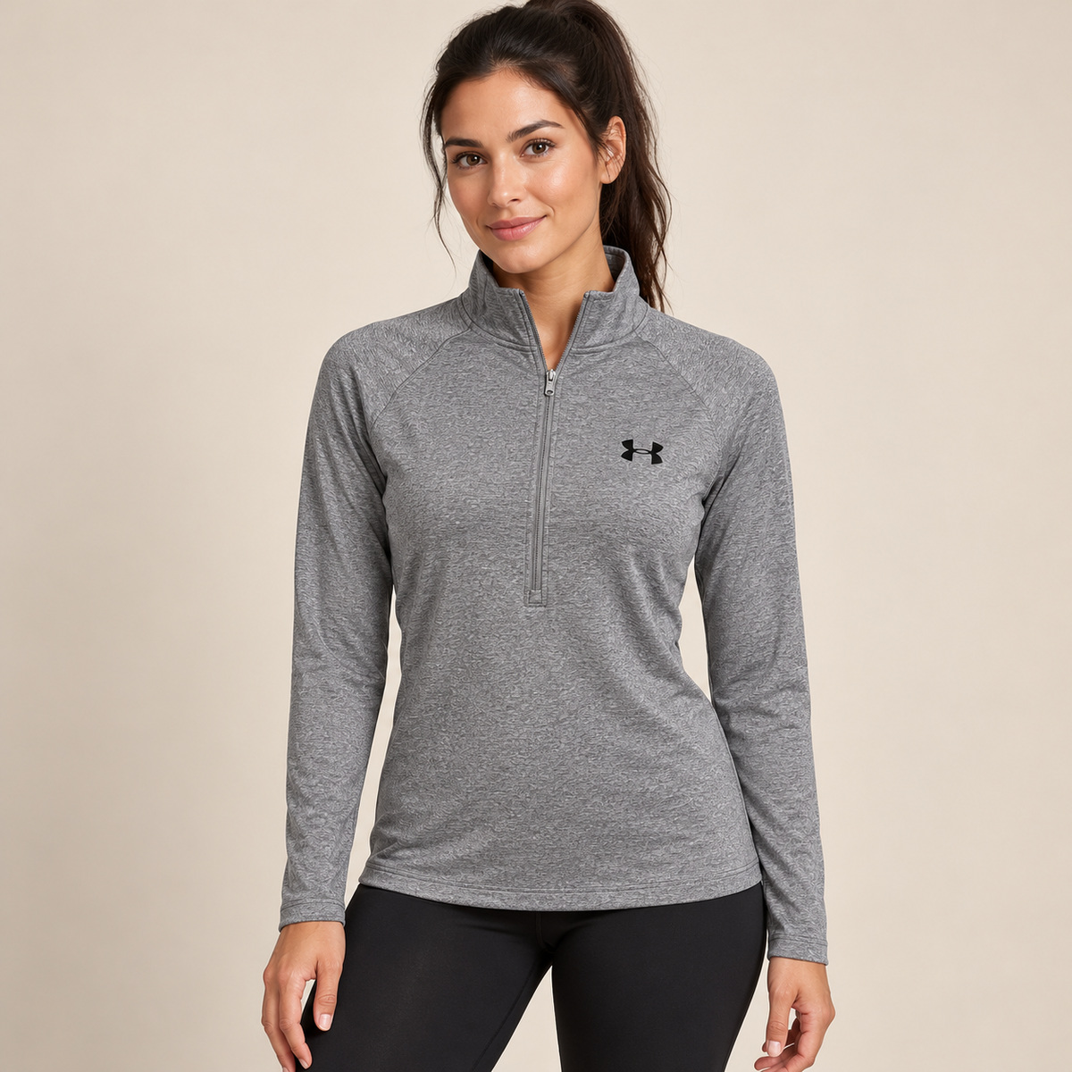 Female model wearing grey marl Under Armour zip-neck top