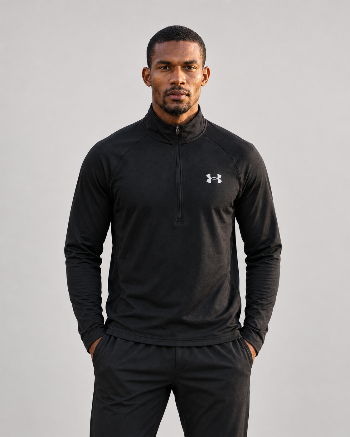 Black Under Armour quarter zip on a male model against a neutral studio background
