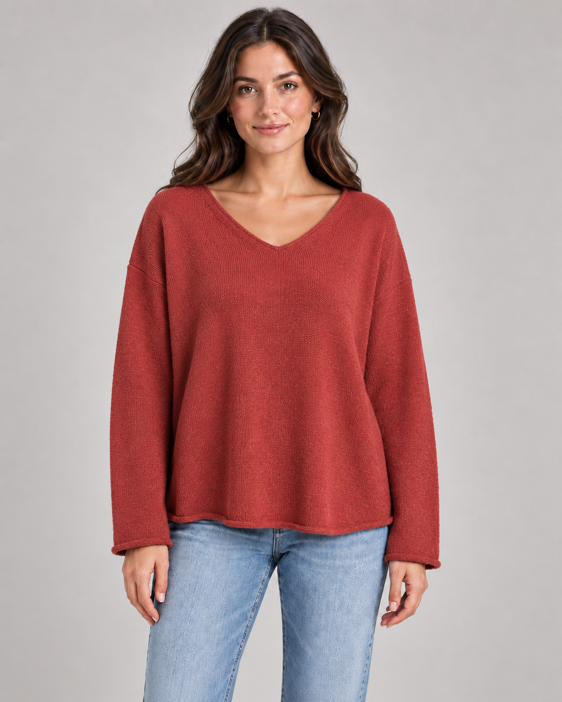 Women's V-neck fine knit top in rust on a female studio model
